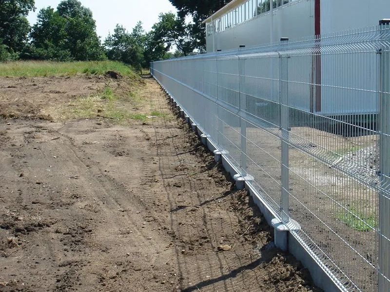 Horganyzott 3D táblás kerítés előregyártott beton lábazaton, ipari épület mellett