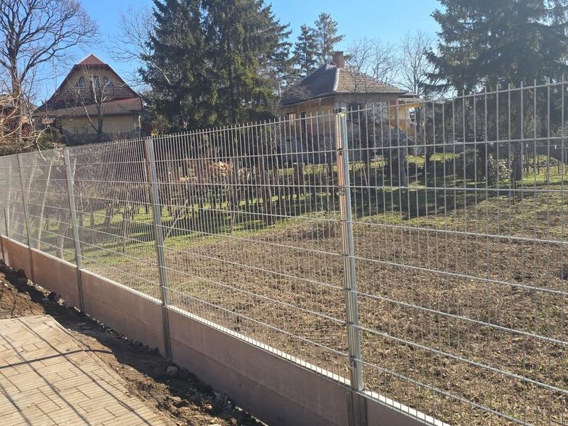 Kész horganyzott 2D táblás kerítésszakasz beton lábazaton, telekhatáron