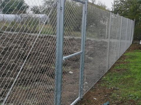 Horganyzott drótfonat kerítés személybejáró kapuval  telekhatáron